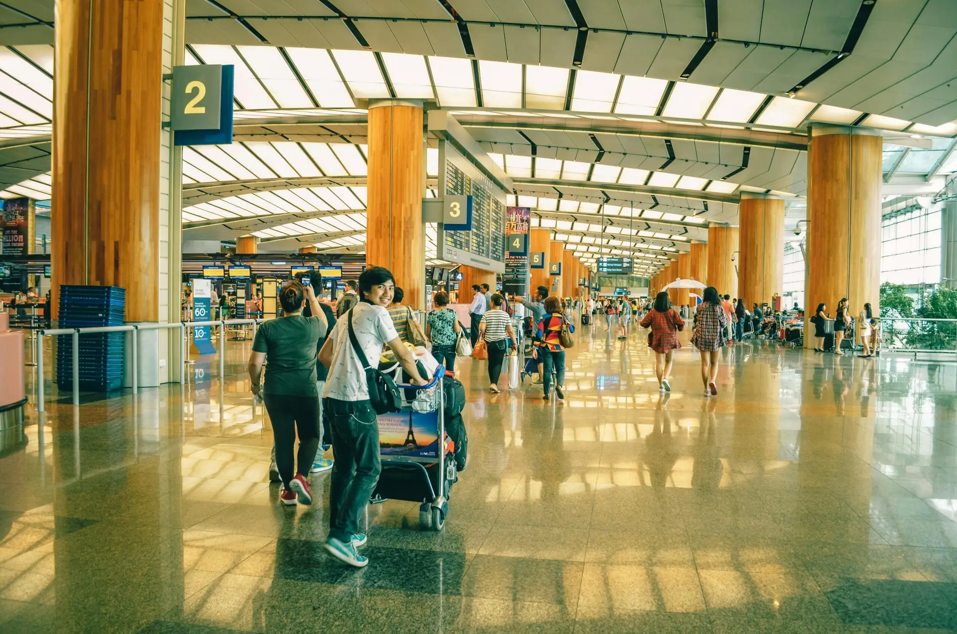 Services Travelers bustling through Singapore Changi Airport terminal, highlighting the dynamic and vibrant atmosphere of international travel.