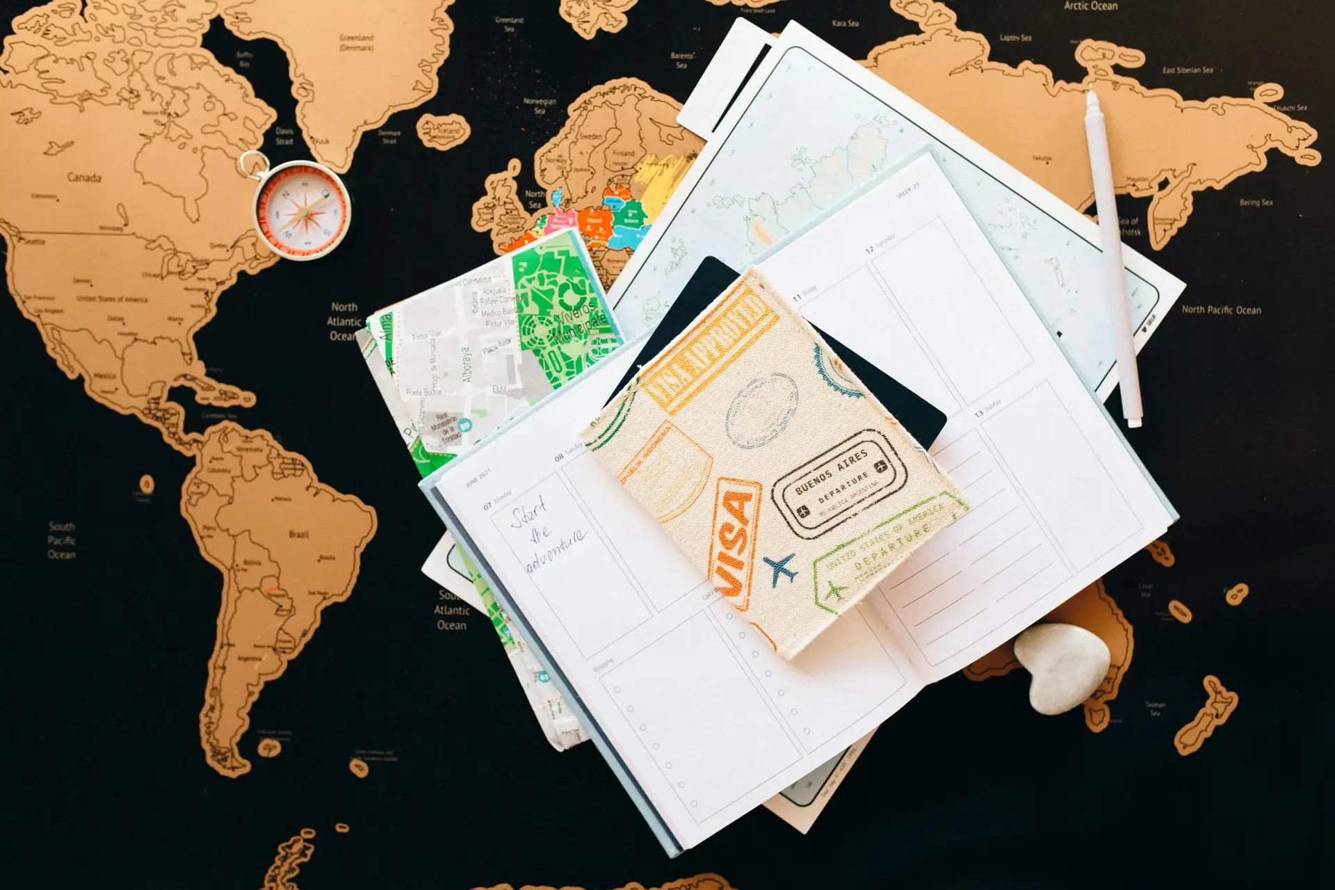 Services A flat lay of travel planning items on a map, featuring a compass, notebook, and guide for wanderlust enthusiasts.